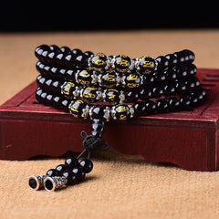 Black Obsidian Mala Bracelet - Coiled on carved wooden stand with gold mantra beads and silver spacers, obsidian prayer beads