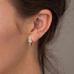 Evil Eye Stud Earrings – Gold evil eye huggie earring worn on earlobe, blue stone detail