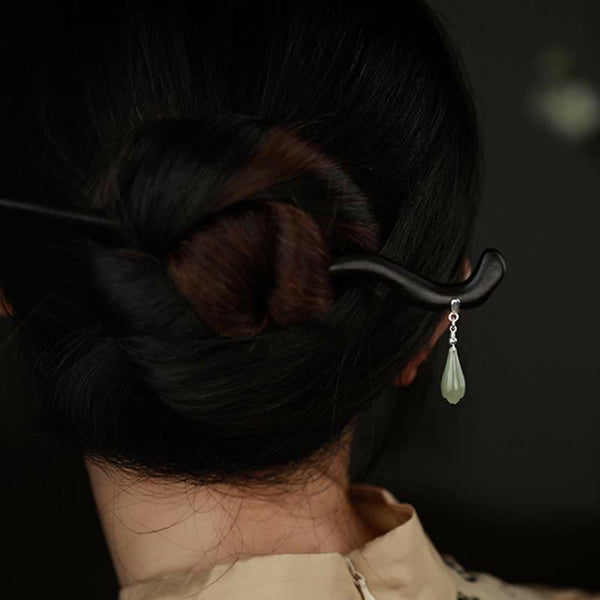 Back view of twisted bun hairstyle with ebony hairpin and pale green jade pendant
