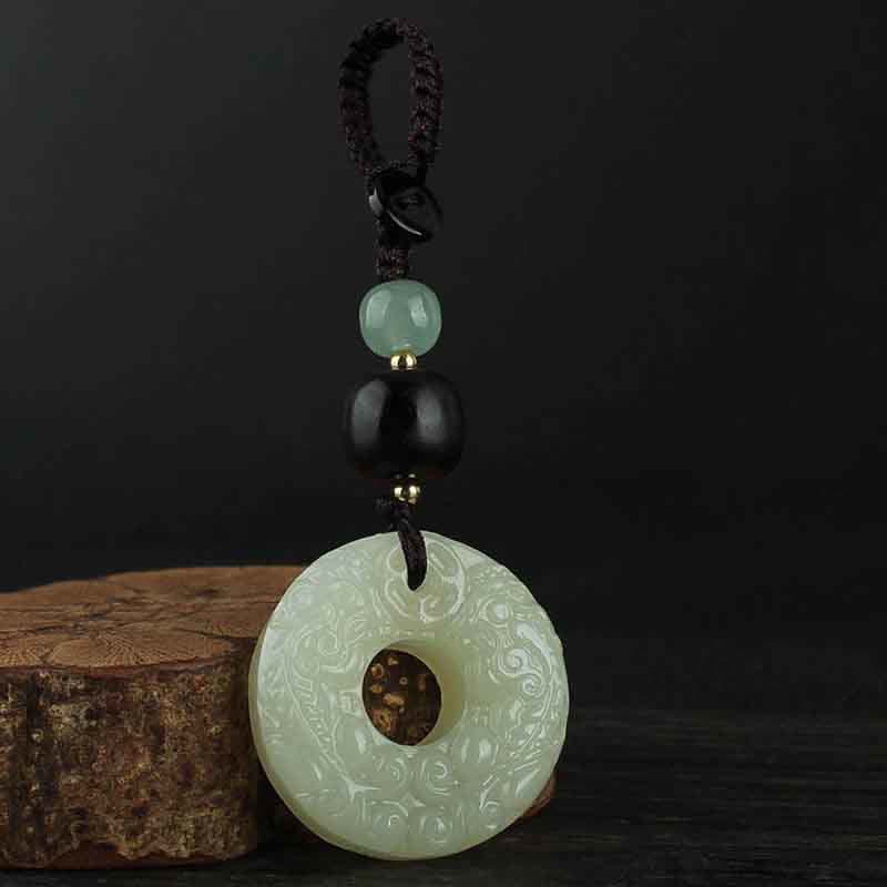 Jade PiXiu Peace Buckle Abundance Key Chain – Jade keychain on wood slice with dark background, abundance charm