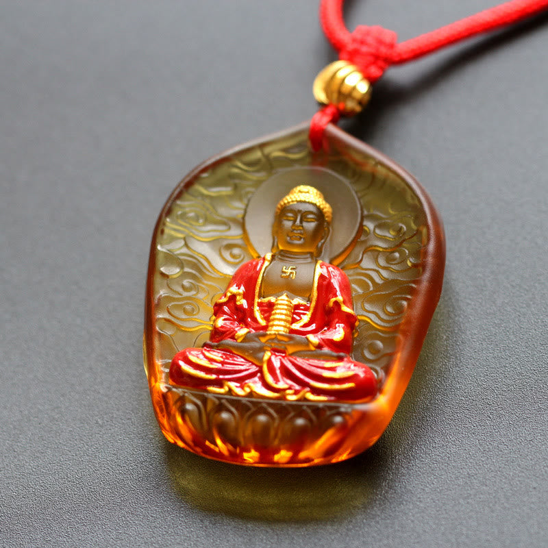 Liuli Crystal Medicine Buddha Pendant – amber liuli with gold Buddha and red robe on red cord, warm tone