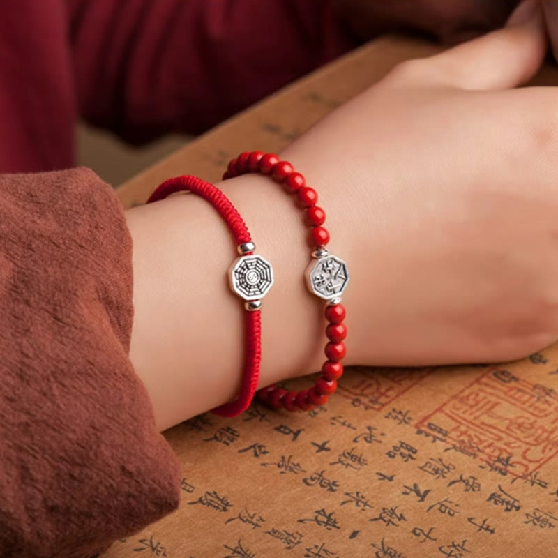 925 Sterling Silver Yin Yang Bagua Cinnabar Bracelet – Red bracelets on wrist over calligraphy parchment, cultural lifestyle