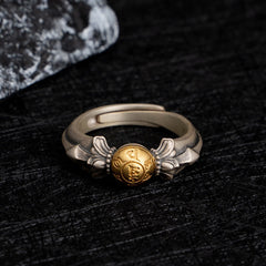 Manjusri Mantra Ring – Elevated view of gold medallion with silver lotus motifs on dark slate, Manjusri jewelry