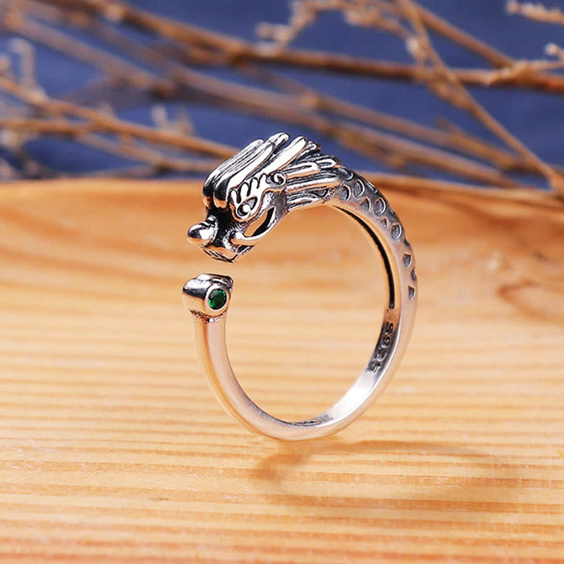 Vintage Dragon Design Ring - Adjustable silver dragon ring with green gem on wood surface, Strength
