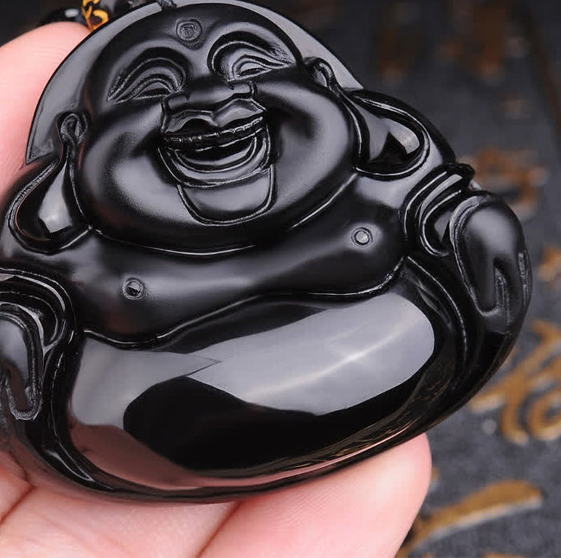 Black Obsidian Laughing Buddha Pendant – hand-held macro showing polished black surface details, grounding energy