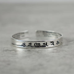 Tibetan Mantra Copper Bracelet - Side view of polished open cuff with engraved mantra, Tibetan bracelet
