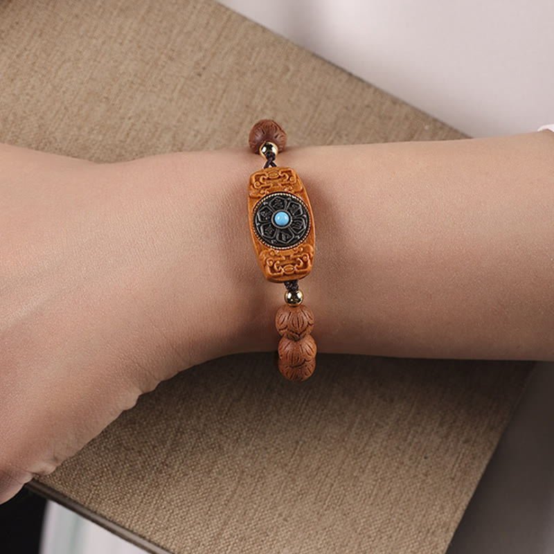 Green Sandalwood & Ebony Soothing Bracelet – on wrist over natural linen, carved lotus bud beads with gold spacers and tur...