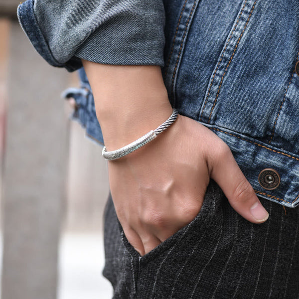 Tibetan Heart Sutra Cuff Bracelet – side view on wrist with hand in pocket, denim jacket styling