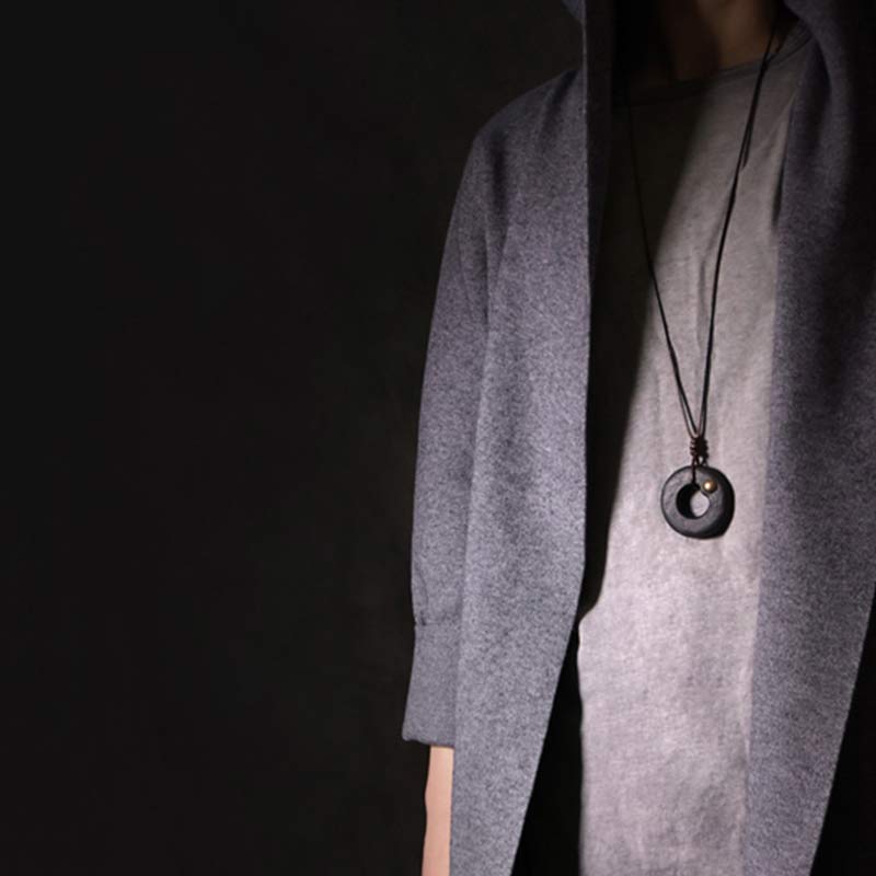 Black Circle Pendant Necklace - geometric ring on black cord with gray layered cardigan, minimalist artisan jewelry