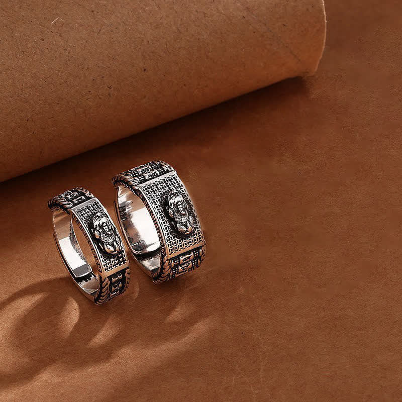 Feng Shui PiXiu Wealth Prayer Wheels Couple Ring – two rings on brown leather displaying matching PiXiu and prayer wheel design, his and hers