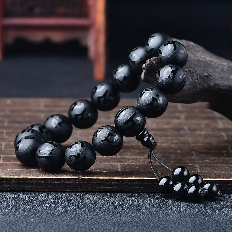 Black Onyx Mantra Bracelet – Polished obsidian beads cascading on weathered wood