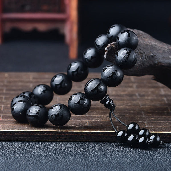 Black Onyx Mantra Bracelet – Polished obsidian beads cascading on weathered wood