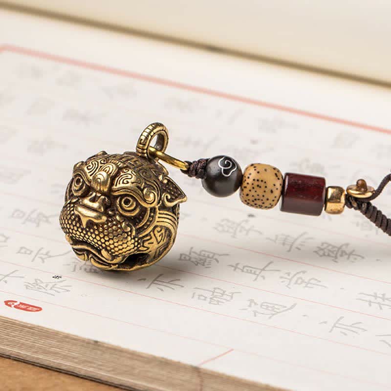 Pixiu Wealth Copper Key Chain – diagonal on calligraphy paper, brass pixiu with rope and decorative beads