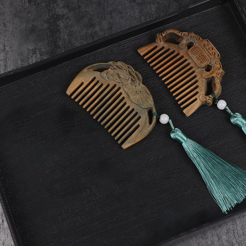 Two green sandalwood carved combs on black tray showing lotus and auspicious designs