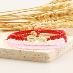 Tibetan Lotus Pink Crystal Red String Bracelet - layered pink bead and red cord design, rustic wheat backdrop
