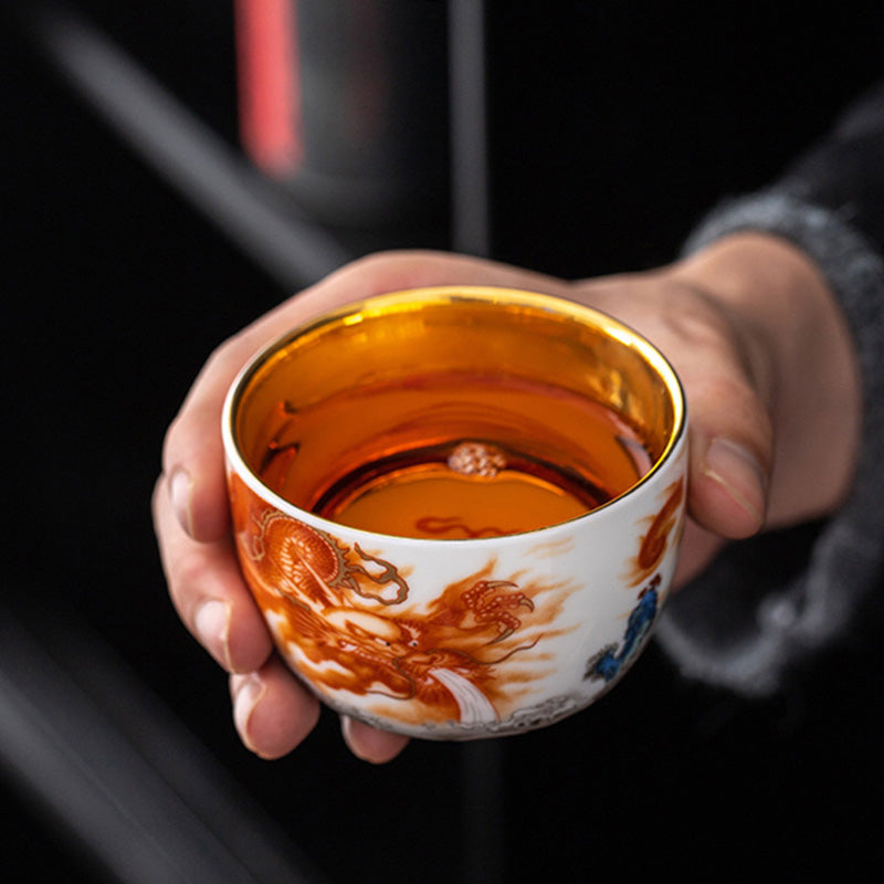 Dragon Phoenix Crane Gilt Ceramic Teacup – gold interior with traditional sun and flame motif, overhead top-down view, handcrafted