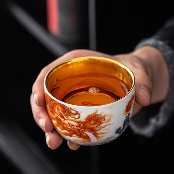 Dragon Phoenix Crane Gilt Ceramic Teacup – gold interior with traditional sun and flame motif, overhead top-down view, handcrafted