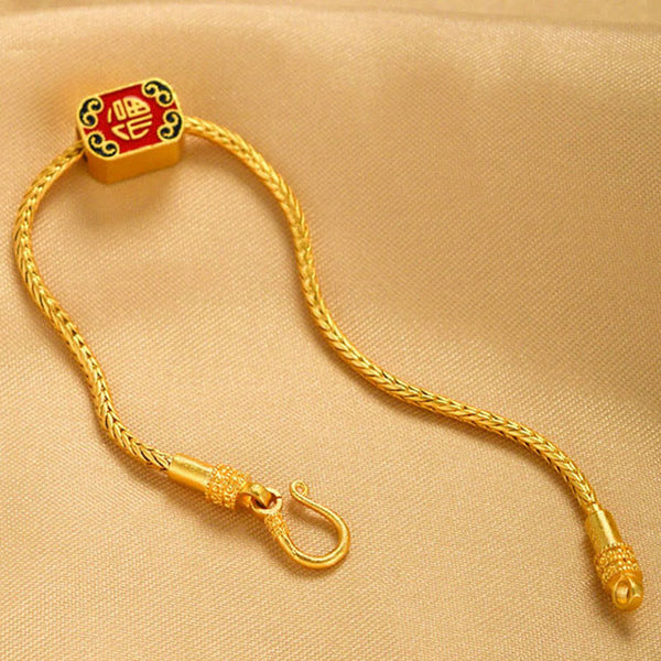 18K Gold Om Mani Padme Hum Koi Fish Bracelet – red Fu character square charm on gold chain, beige fabric, diagonal top-down view