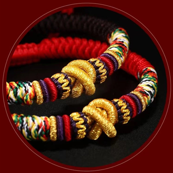 Tibetan Mantra Bracelet – Close-up of gold decorative knots with rainbow woven cord, traditional craft