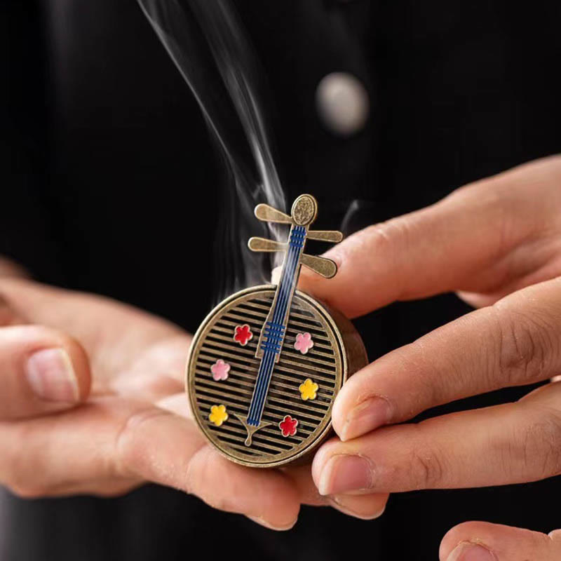 Copper Incense Burner Set – yueqin-shaped burner cradled in hands, enamel flowers, smoke rising