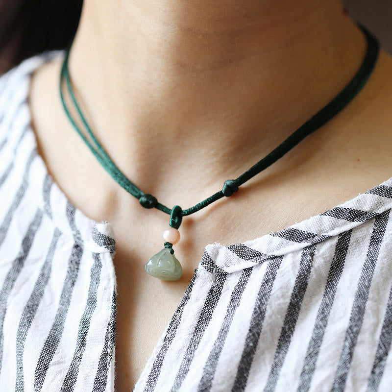 Jade Peace Buckle Lotus Necklace – Carved jade pouch pendant worn on striped shirt with sliding knot, jade necklace