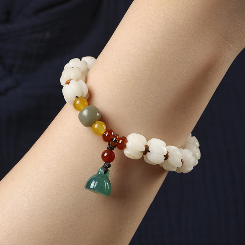Bodhi Seed Lotus Bead Bracelet - worn on wrist, carved white lotus with green pendant