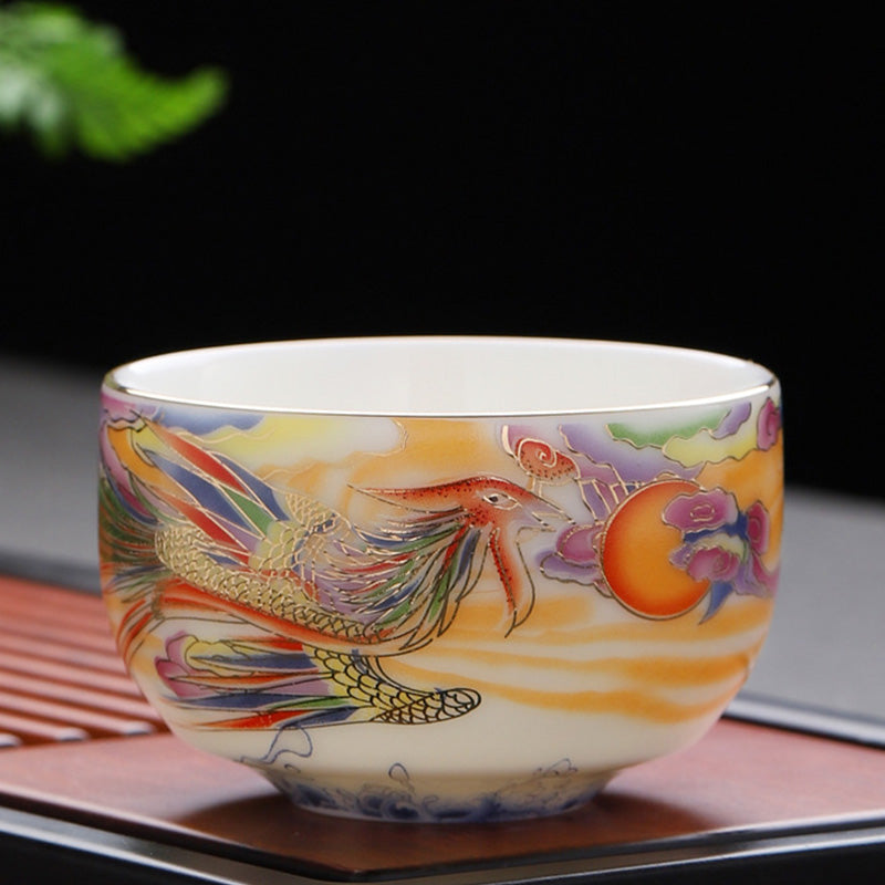 Dragon Phoenix Ceramic Teacup - Iridescent phoenix facing sun disk on dark background, ornate