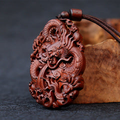 Lightning Jujube Wood Dragon Pendant - 3/4 view on driftwood prop, rich reddish-brown grain, Spiritual