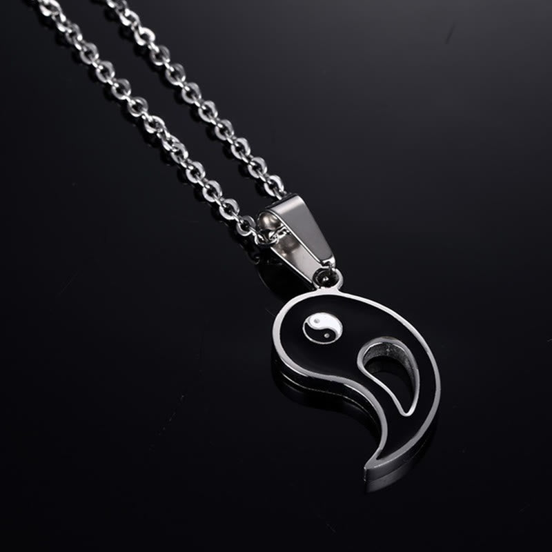 Yin Yang Pendant Couple Necklace Set - Black yin-yang pendant half with silver chain on dark reflective surface, couples j...