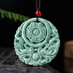 Dragon Jade Yin Yang Necklace – Green jade donut pendant on black cord worn on collarbone, dark gray textured background, lifestyle side shot