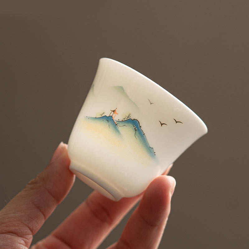 Ceramic Kung Fu Tea Cup – mountain pavilion scene held in hand showing translucent ivory porcelain, intimate scale