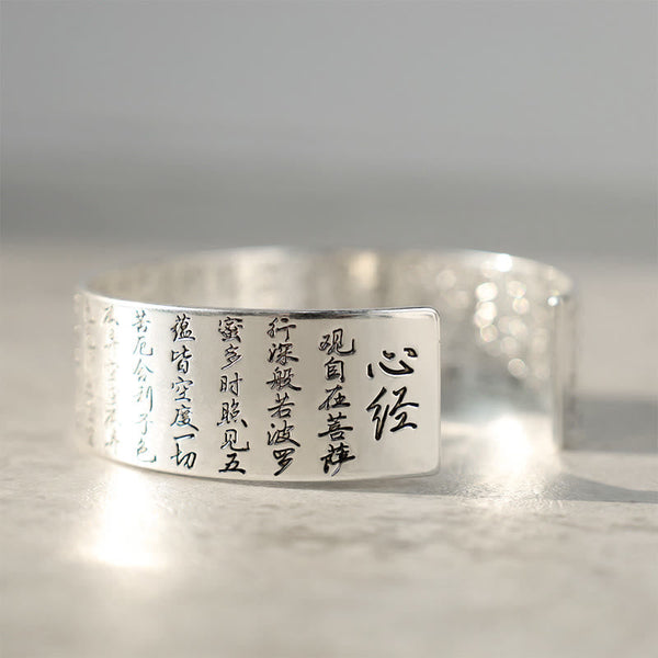 Tibetan Lotus White Copper Luck Bracelet - Silver cuff engraved with Heart Sutra text low angle, Sacred scripture