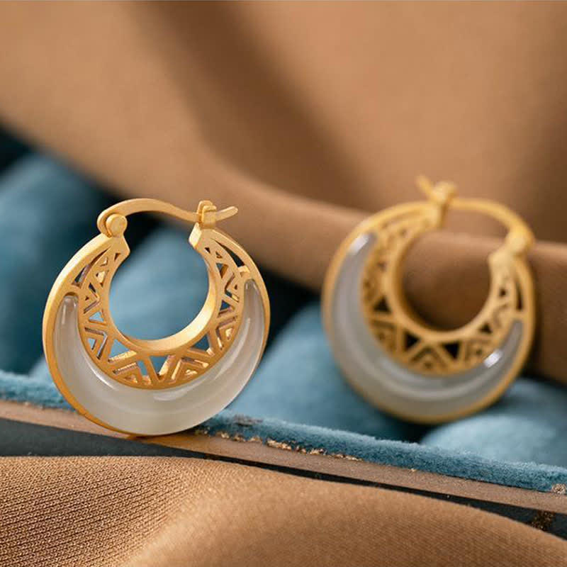 Crescent Moon Jade Drop Earrings – Gold hoop earrings with translucent white jade crescent inlay and openwork geometric patterns, on white background, frontal shot