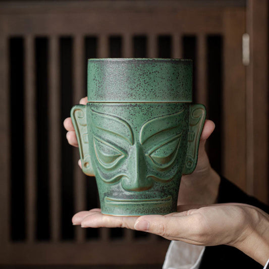 Sanxingdui Bronze Mask Incense Burner – Held in both hands showing mask face and green patina, cultural ceramic burner