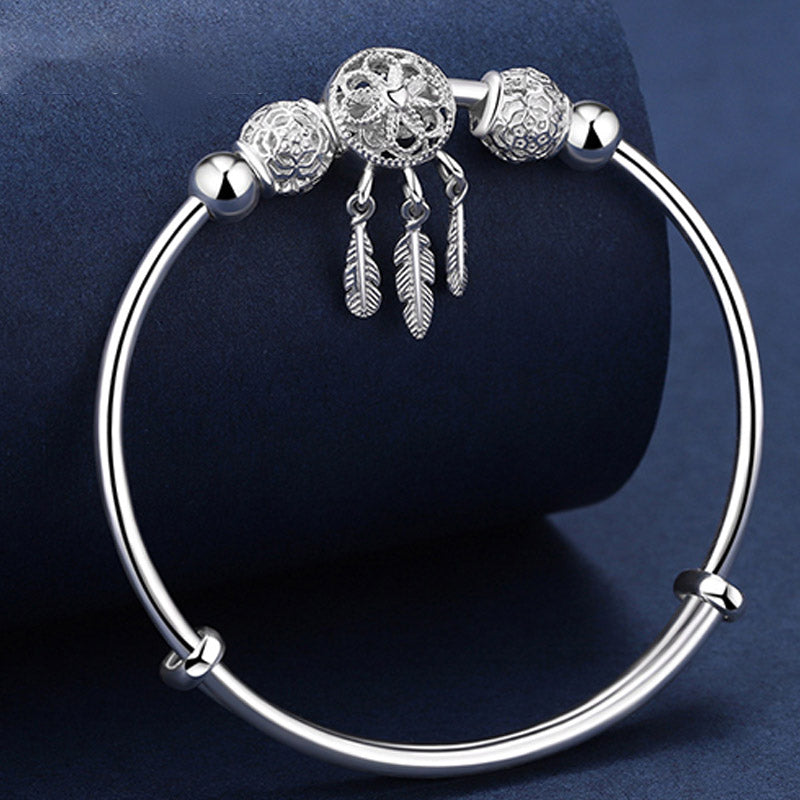 Dream Catcher Blessing Bracelet – Silver bangle on navy stand showing full dreamcatcher front, display stand shot