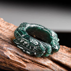 Cyan Jade Dragon Success Ring on driftwood, dragon head detail, deep teal stone, carved jade ring