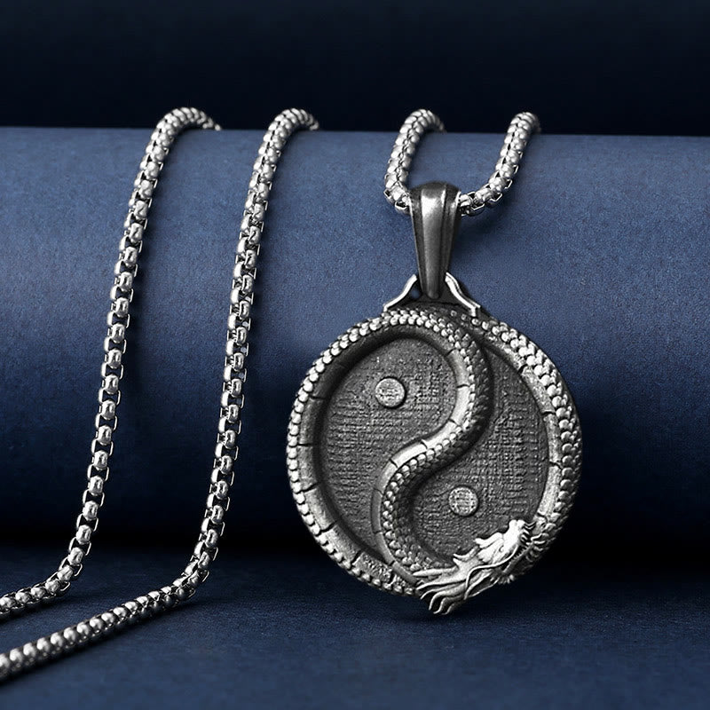 Yin Yang Dragon Pendant – Draped on navy stand revealing carved relief and chain, Mystical