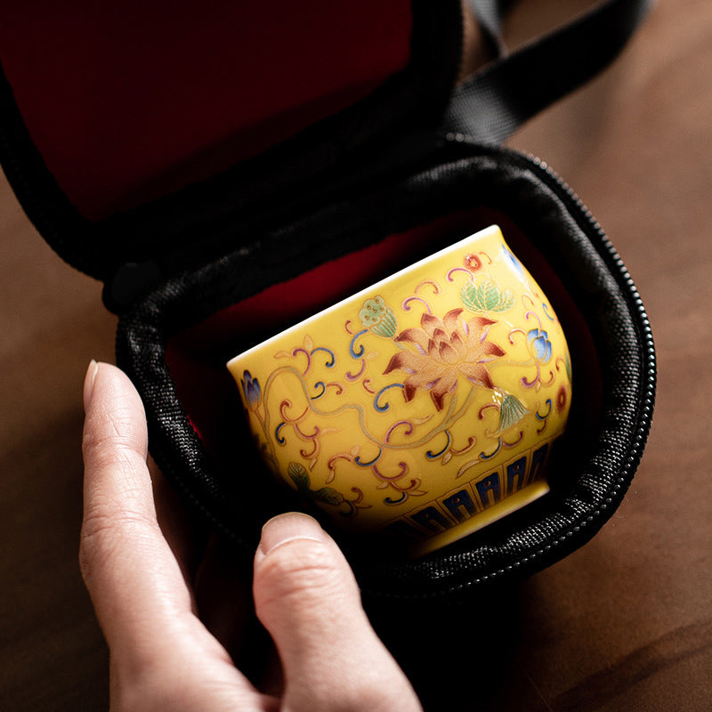 Lotus Pod Ceramic Tea Cup – yellow enamel cup nestled in red brocade carrying case