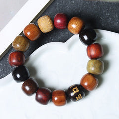 Multi-Wood Mala Bracelet – carved sandalwood and gold-inlaid ebony beads on ceramic dish, spiritual bracelet