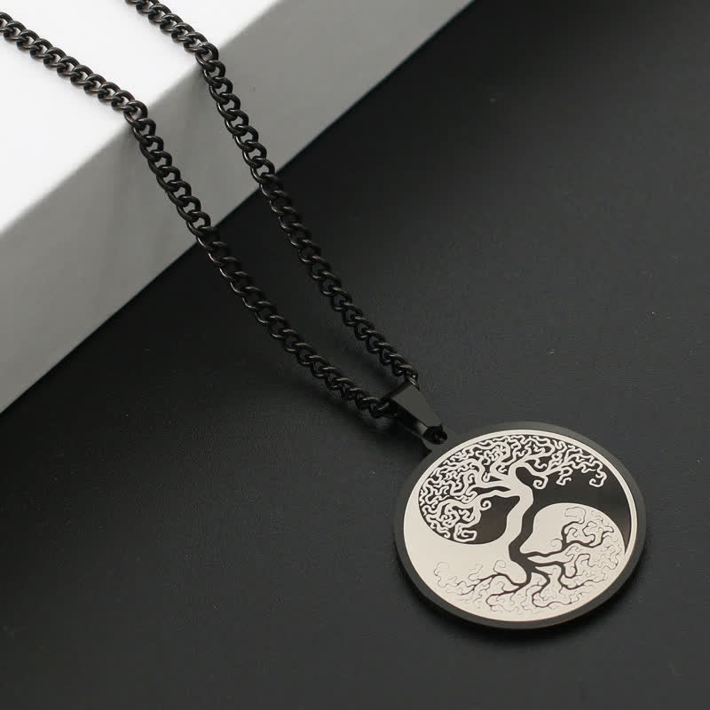 Tree of Life Titanium Steel Necklace – black pendant on dark surface with white block, angled view, connection pendant