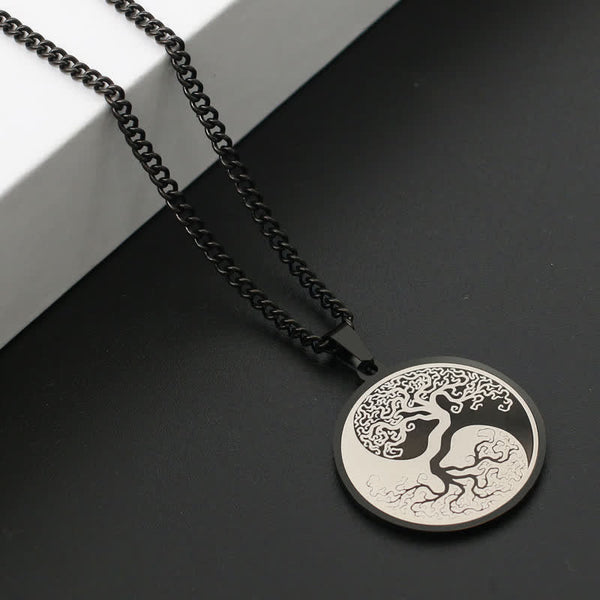 Tree of Life Titanium Steel Necklace – black pendant on dark surface with white block, angled view, connection pendant
