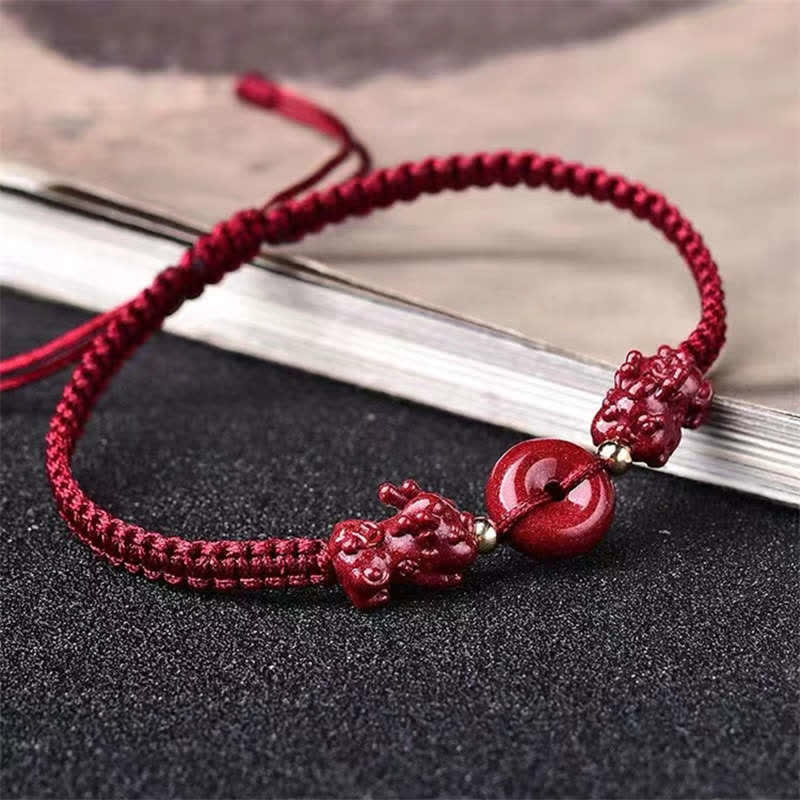 Cinnabar PiXiu Copper Coin Red String Bracelet – Red cord with PiXiu and peace buckle on black texture, zen