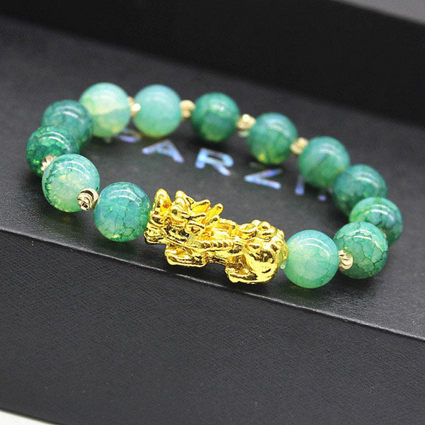 Cyan Jade PiXiu Success Bracelet – close-up of gold PiXiu with textured green jade beads on black surface, wealth luck jewelry