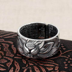 999 Silver Lotus Ring – detailed lotus bloom relief on dark embroidered fabric