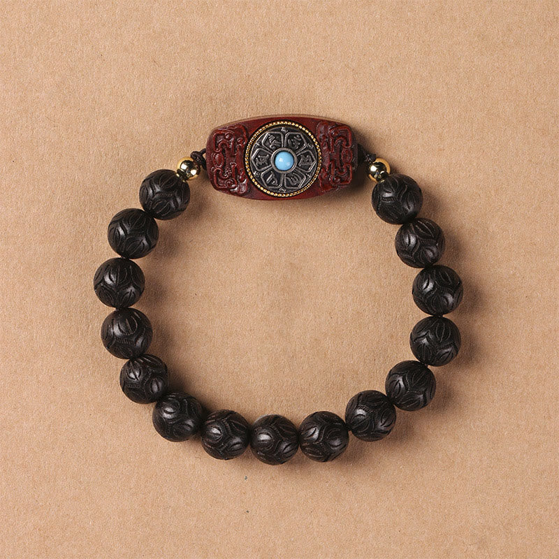 Green Sandalwood & Ebony Soothing Bracelet – overhead view of dark ebony beads with carved red barrel charm and turquoise ...