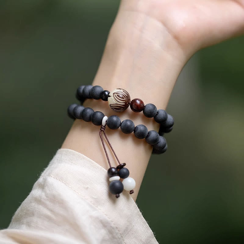 Tibetan Cypress Bodhi Lotus Bracelet - double-wrap on wrist with lotus bead, green backdrop, peaceful