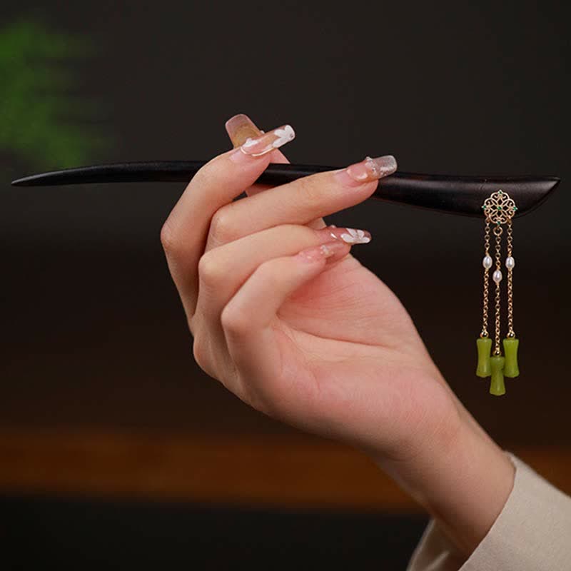 Peridot Ebony Wood Hairpin, hand holding ebony hairpin with peridot and pearl tassel detail