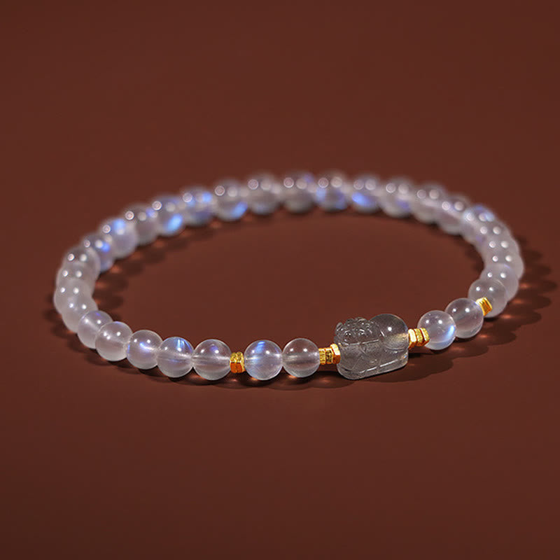 Moonstone PiXiu Bracelet – Close-up of PiXiu charm between moonstone beads on brown, crystal healing