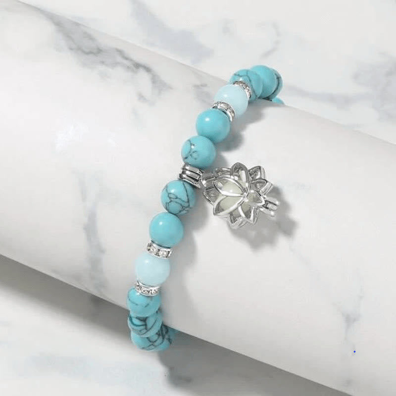 Tibetan Turquoise Glowstone Lotus Bracelet – turquoise beads with white accent beads on white marble stand, turquoise bracelet