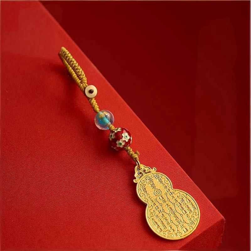 Antique gold gourd keychain with gold cord on red gift box
